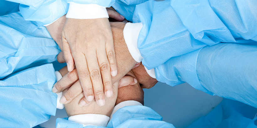 Small group of doctor team joining hands